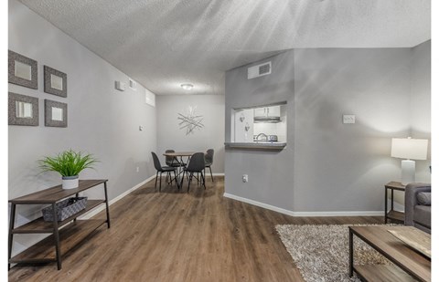 the living room and dining area of a house with a table and chairs